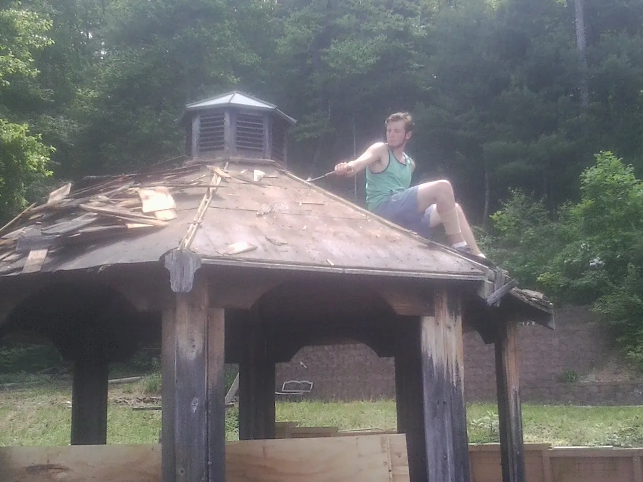 Tearing the old roof off a wooden gazebo before new shakes in Sylvania